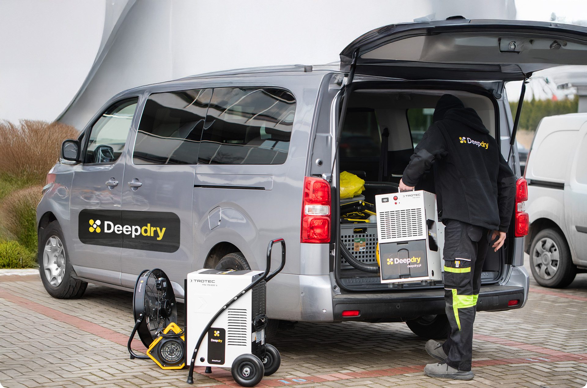 mężczyzna wypakowujący sprzęt osuszający