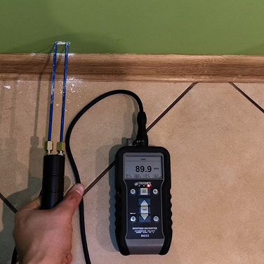 Osuszanie domu po zalaniu w wyniku pękniętego węzyka od wody, pomiar wilgotności podposadzkowy